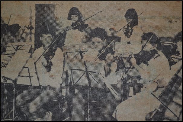 A school-aged, curly hair Philip Trigg on violin (centre). 